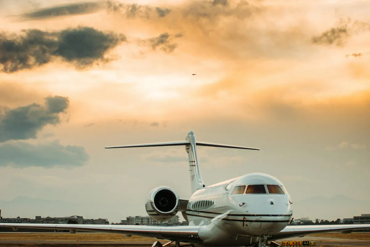 Large business jet on the runway under a golden sky
