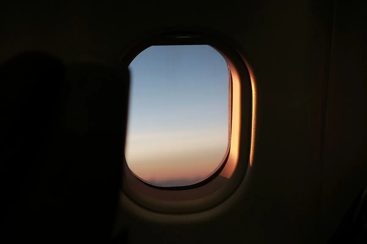 Cabin window at dusk with the sky glowing orange